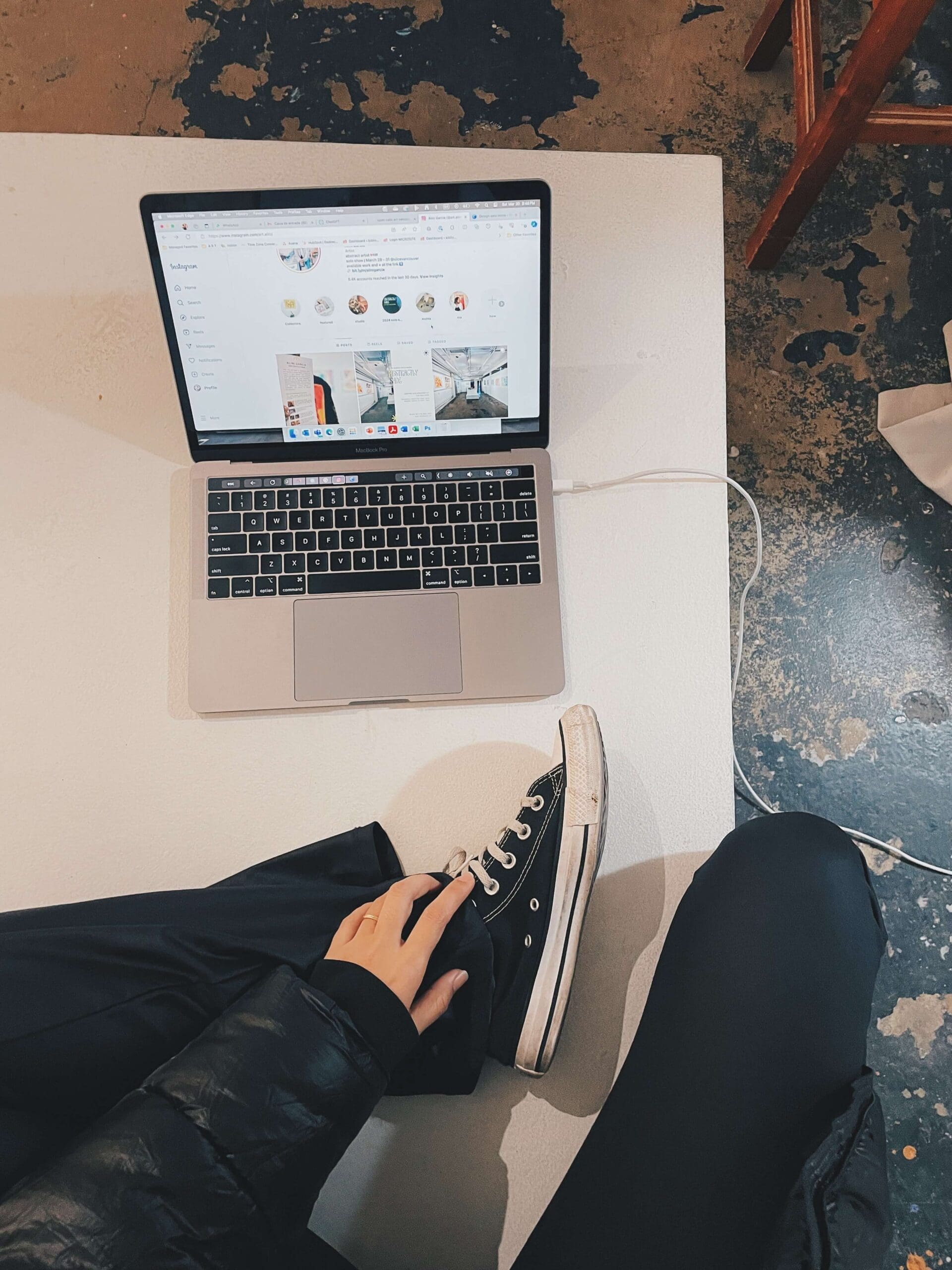 Woman in Converse working on a laptop while building multiple income streams after quitting her job