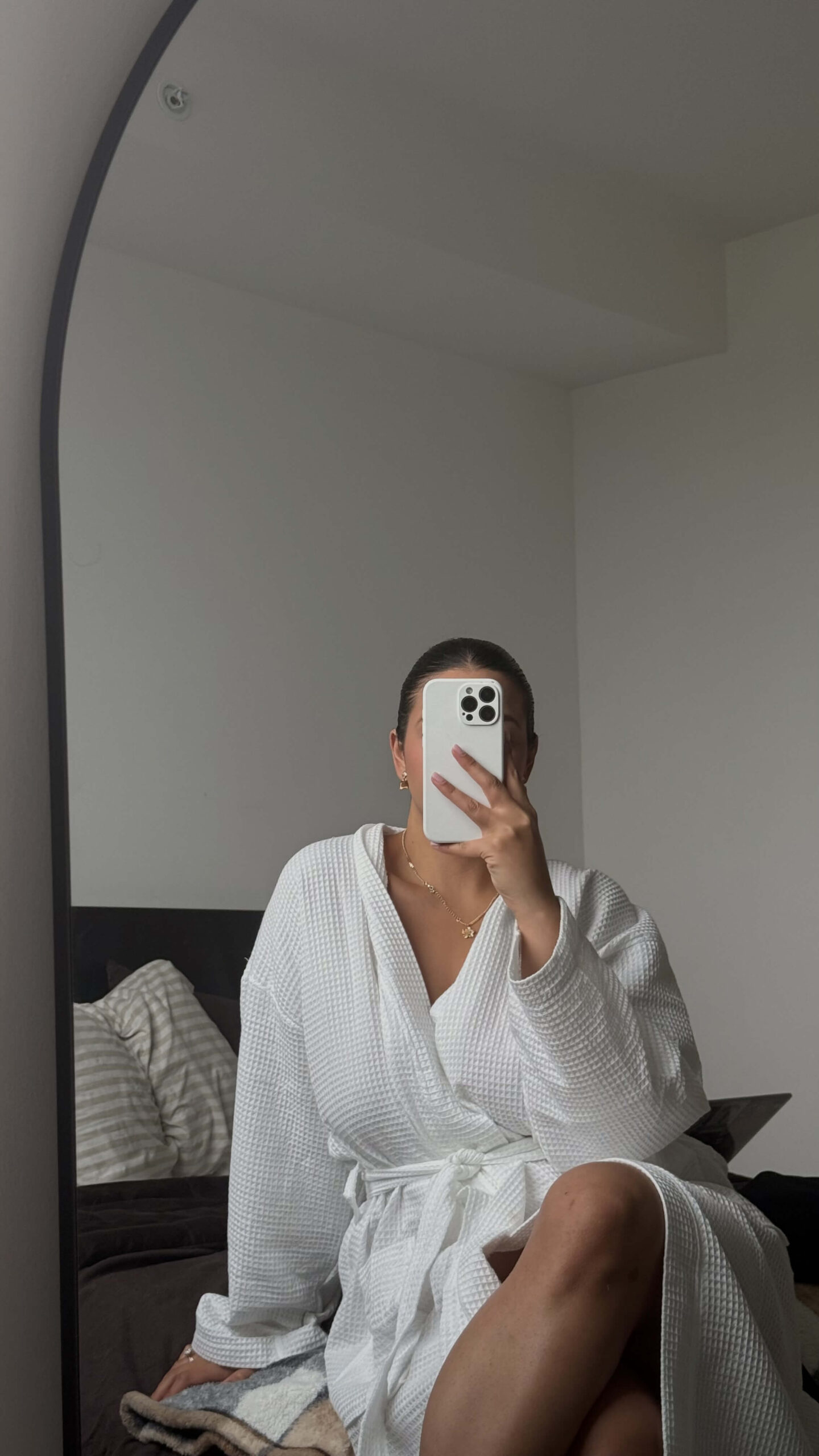Full image of a woman in a white bathrobe to showcase how to stop drinking in a full length mirror